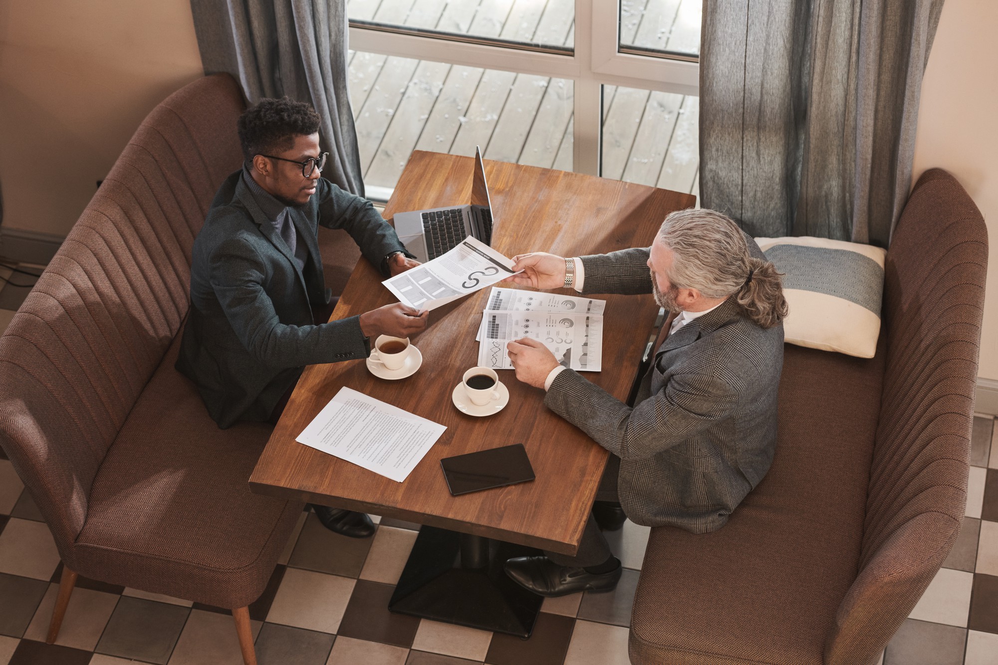 Agent imobiliar discutând planuri cu clienți într-un birou elegant